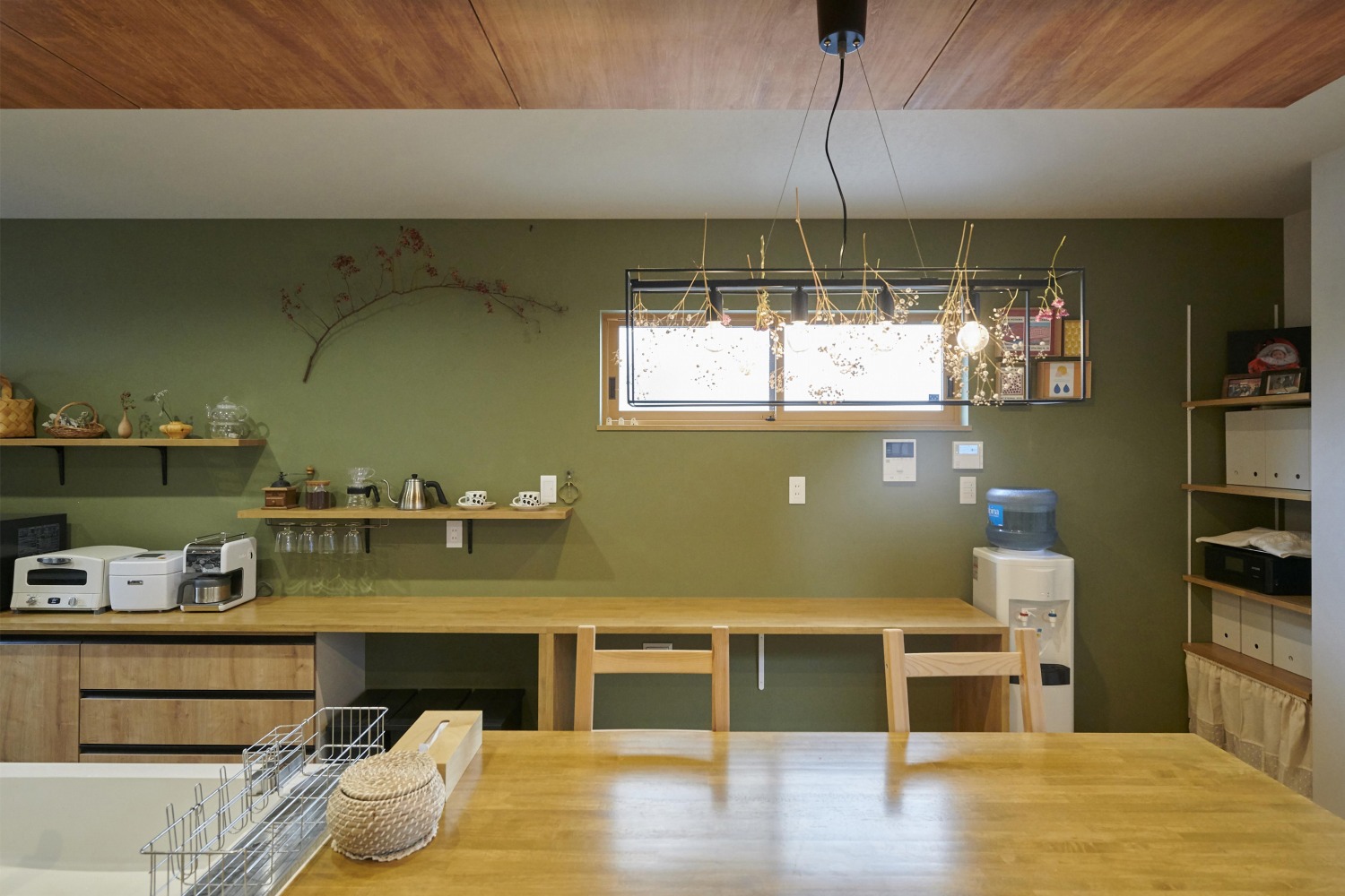 壁を緑色にし、空間に統一性を持たせるキッチンの画像
