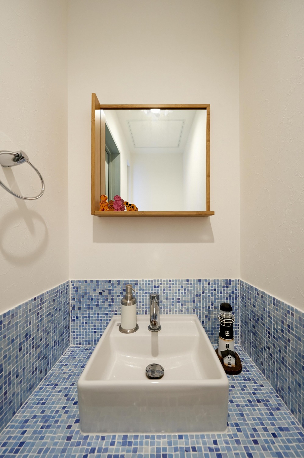 四角い鏡と青色タイルがおしゃれなカフェのような洗面台の画像