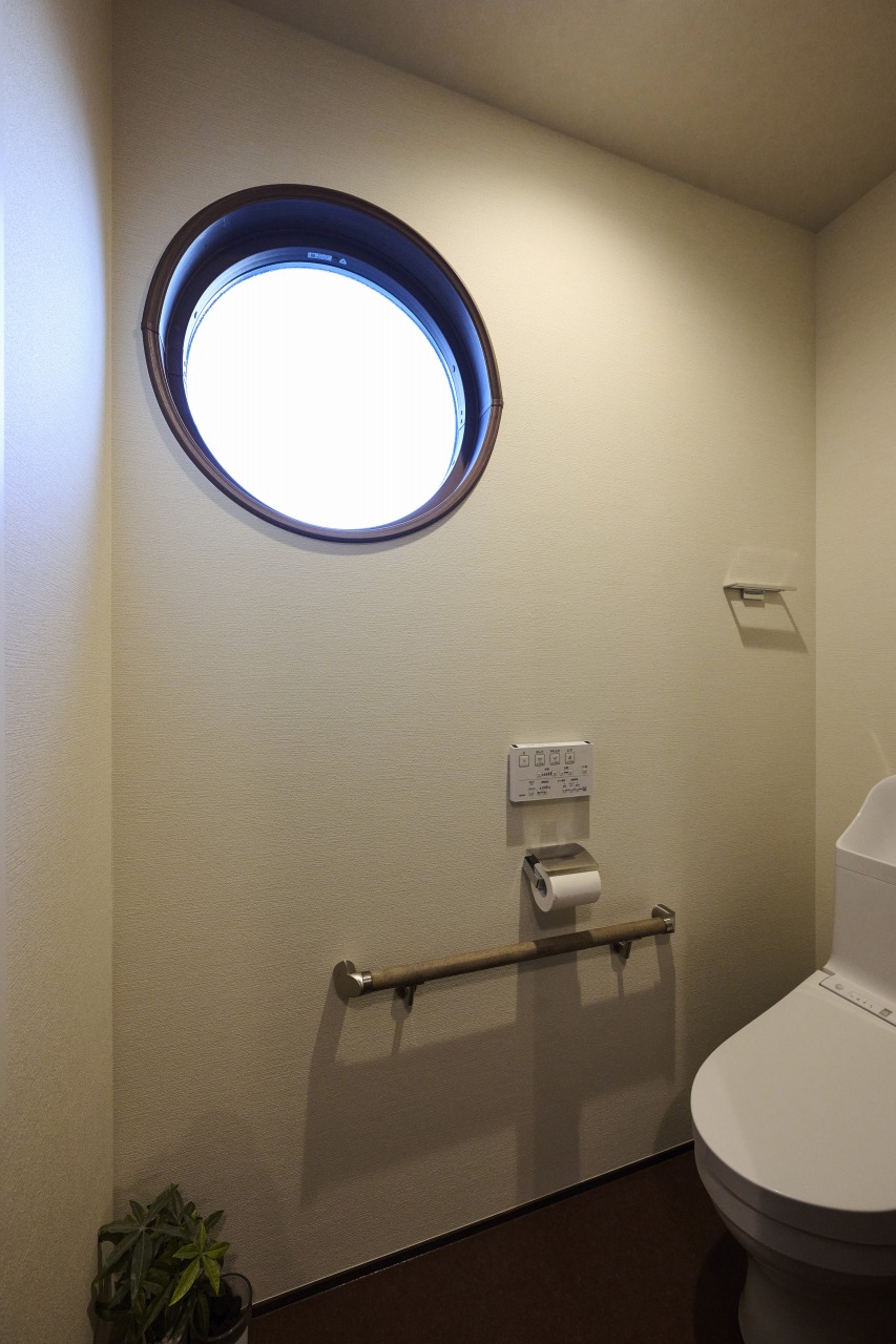 趣と柔らかさのある丸窓を採用したトイレの画像