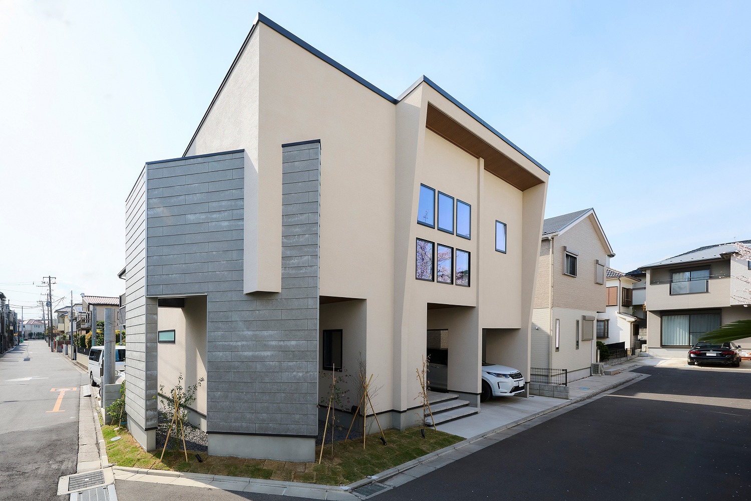 窓に映る桜が美しさを添える外観デザインの画像