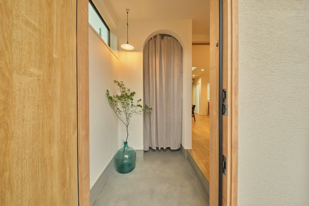 緩やかに空間を区切るアーチの壁を作った玄関の画像