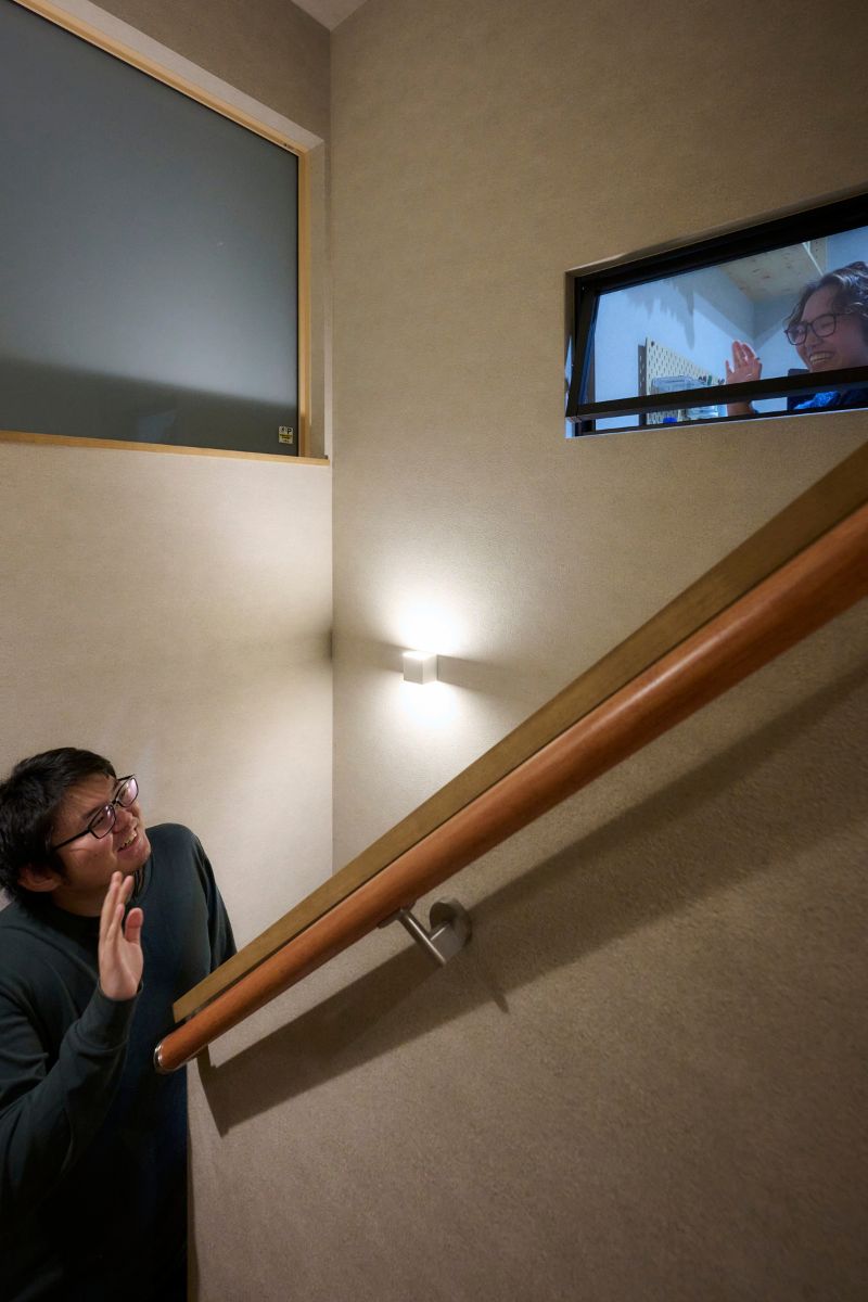 家族がゆるやかに繋がる、書斎に設けた室内窓が見える階段の画像